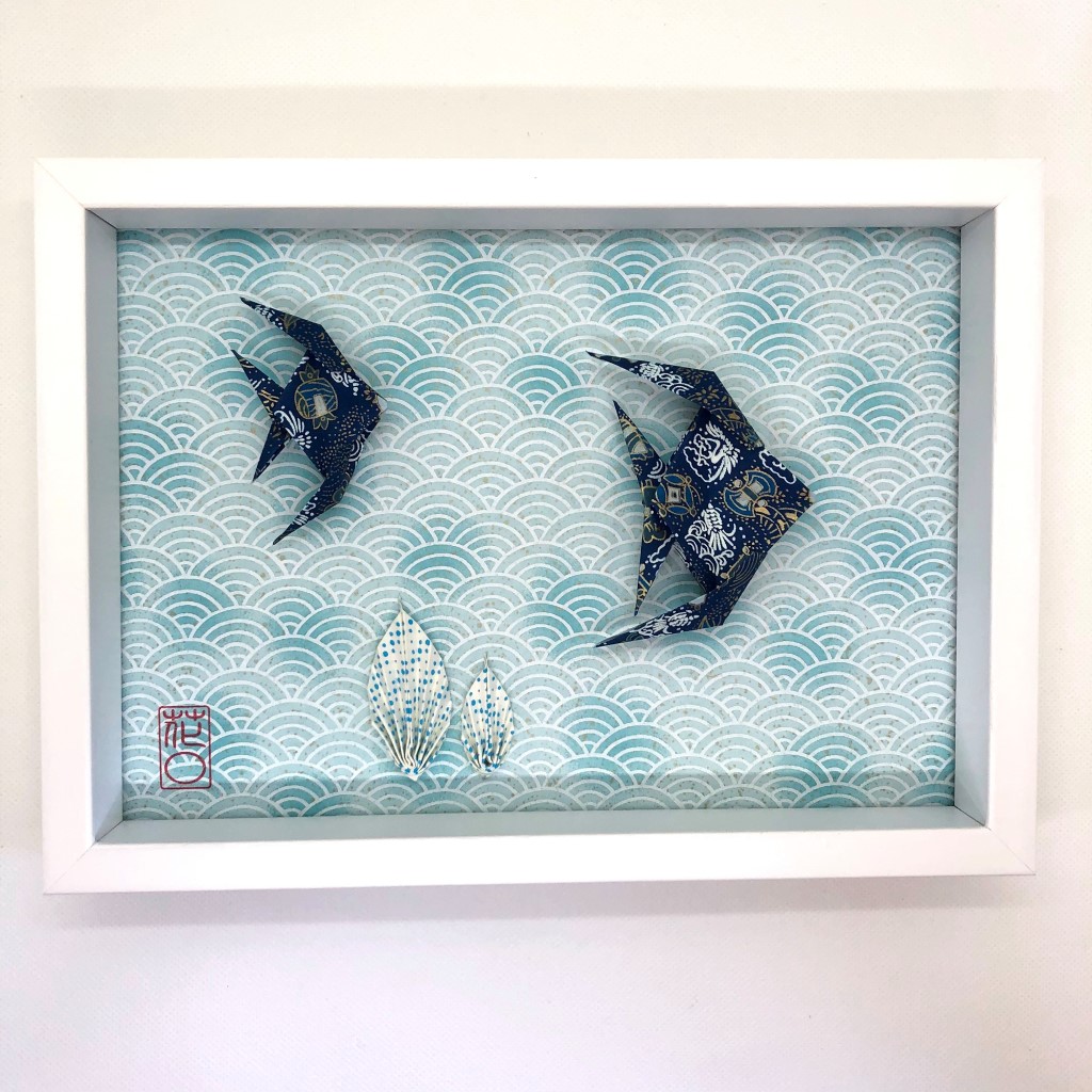 Cadre blanc avec origami poissons bleus et algues
